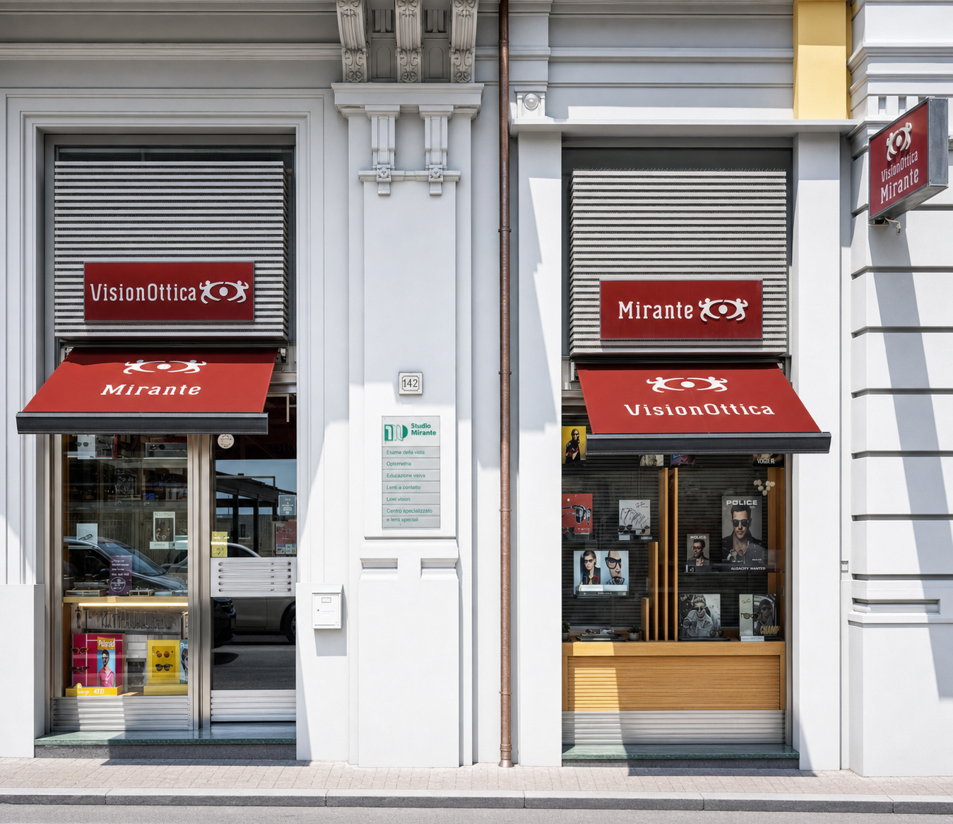 Facciata del negozio VisionOttica Mirante di Formia su strada con due moduli affiancati, tende bordeaux retratte, porta aperta a sinistra e vetrina a destra con espositori di occhiali e poster