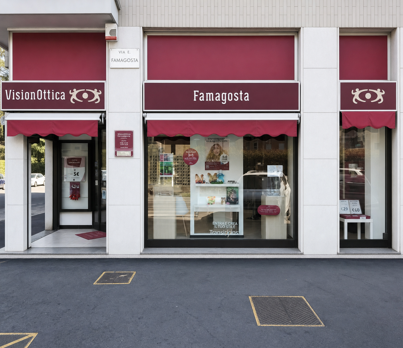 Facciata del negozio VisionOttica Famagosta di Milano su strada con doppia tenda bordeaux, insegna laterale, porta d'ingresso a sinistra e ampia vetrina con accessori