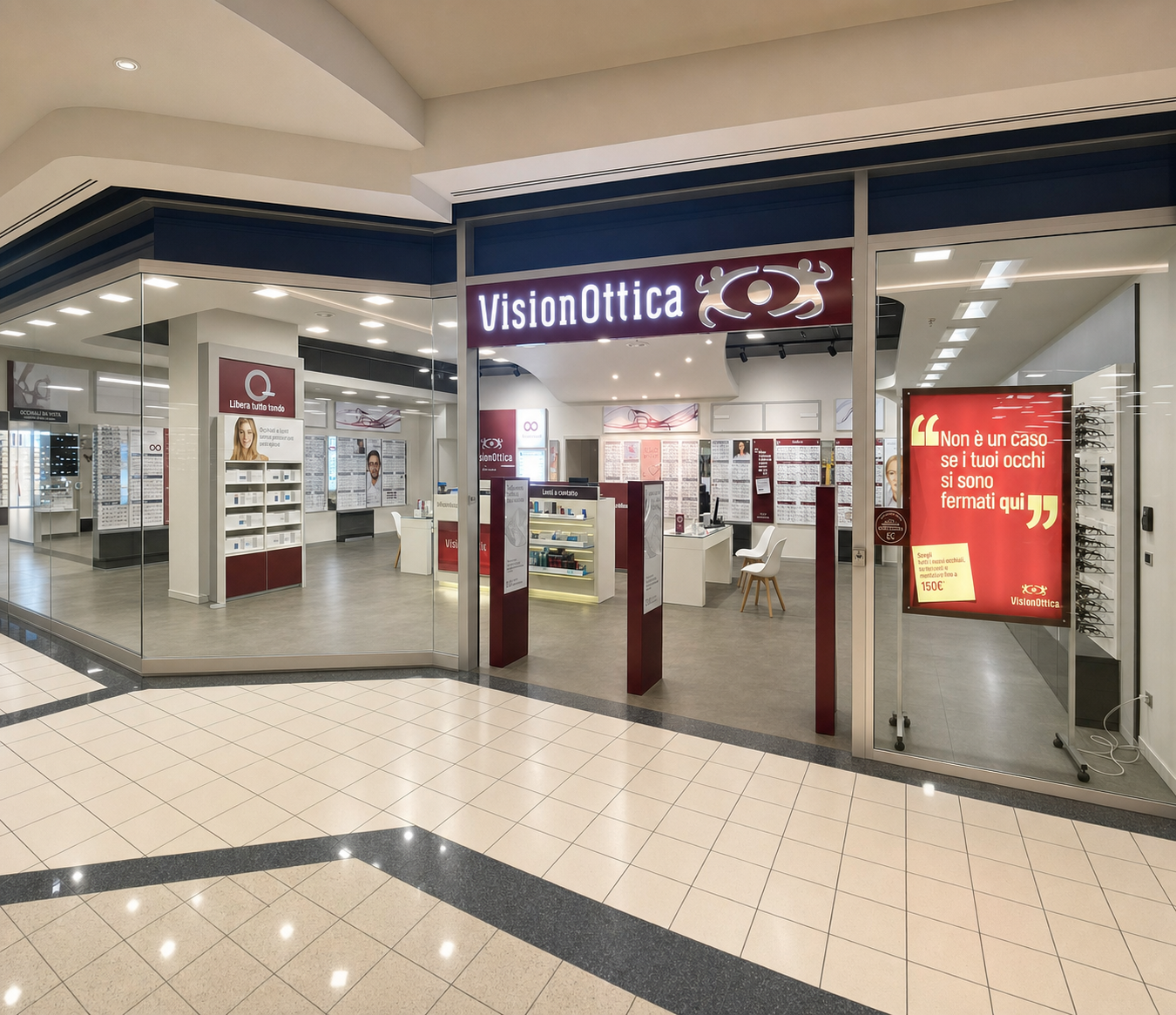 Ingresso del negozio VisionOttica Varallo di Varallo Pombia in centro commerciale con ampia vetrata, insegna bordeaux su fascia blu e schermo promozionale rosso laterale