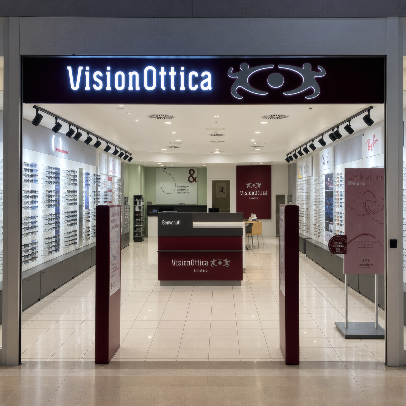 Ingresso del negozio VisionOttica Emisfero di Perugia in centro commerciale con insegna retroilluminata, bancone centrale e espositori a parete su pavimento chiaro