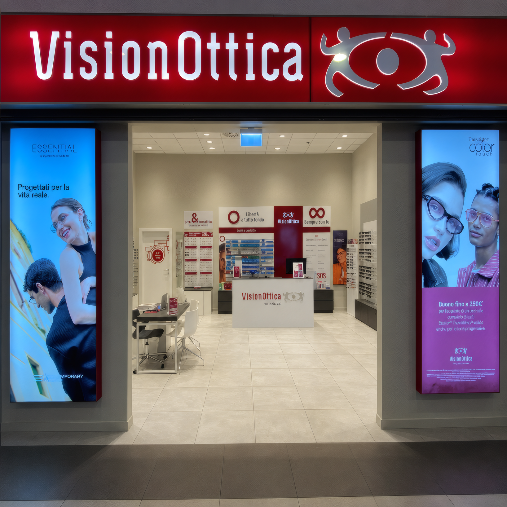 Ingresso del negozio VisionOttica Viterbo CC di Viterbo in centro commerciale con insegna rossa luminosa, ampia apertura frontale su interno con totem digitali laterali, bancone centrale e espositori di occhiali da vista e da sole