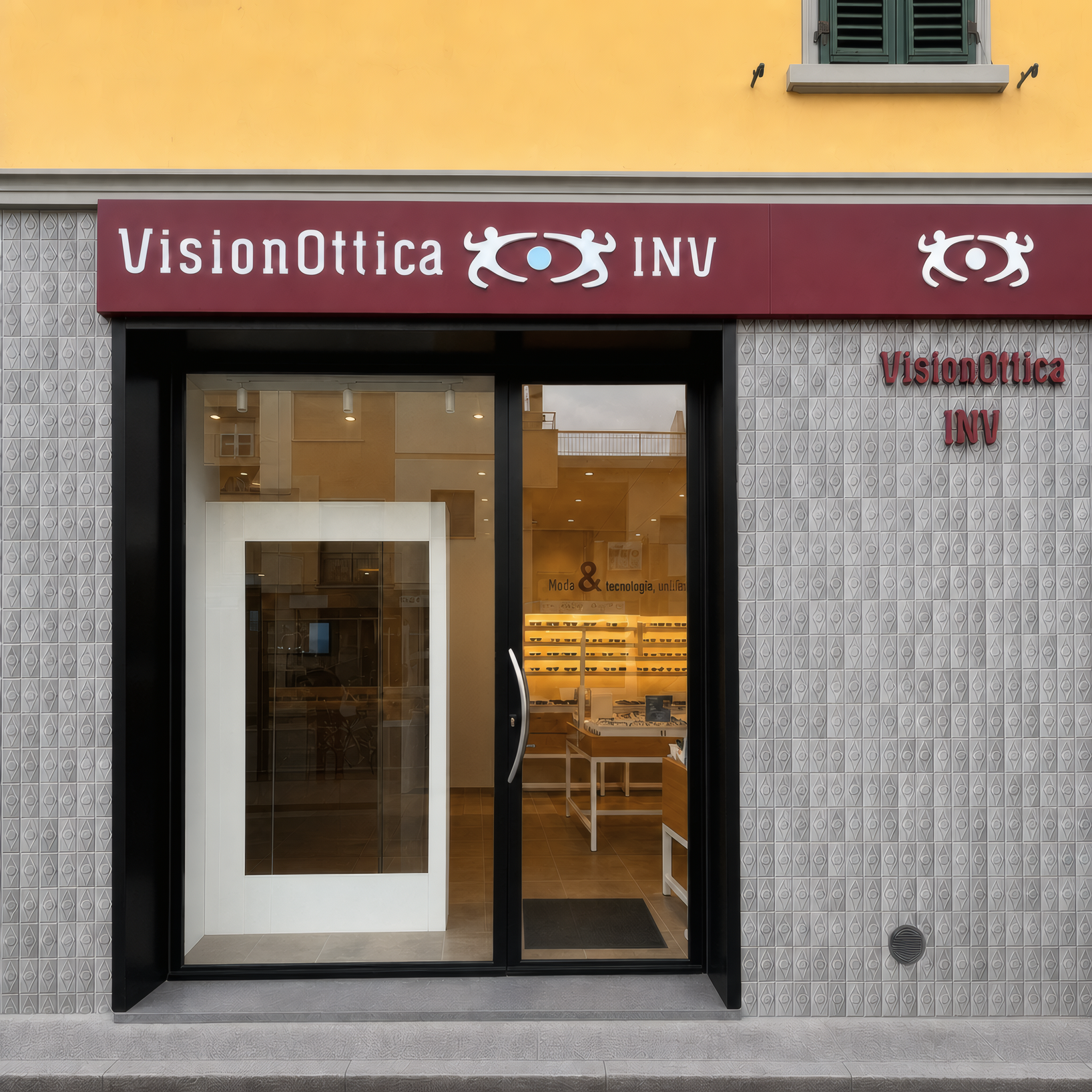 Facciata del negozio VisionOttica INV di Scandicci su strada con insegna bordeaux, porta centrale e vetrina con espositori di montature