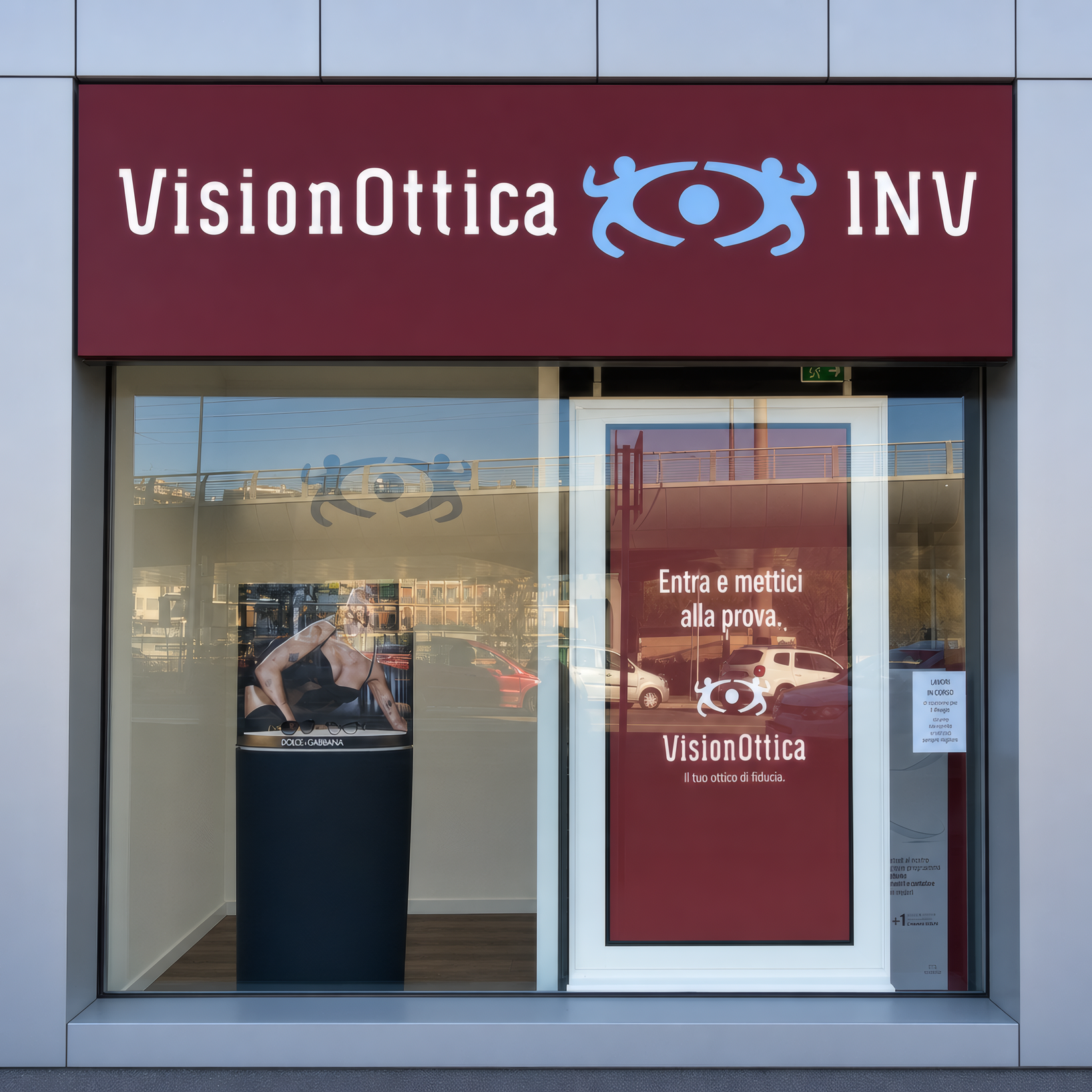 Ingresso del negozio VisionOttica INV di Firenze in centro commerciale con vetrina a tutta altezza, insegna bordeaux e locandina promozionale sulla porta