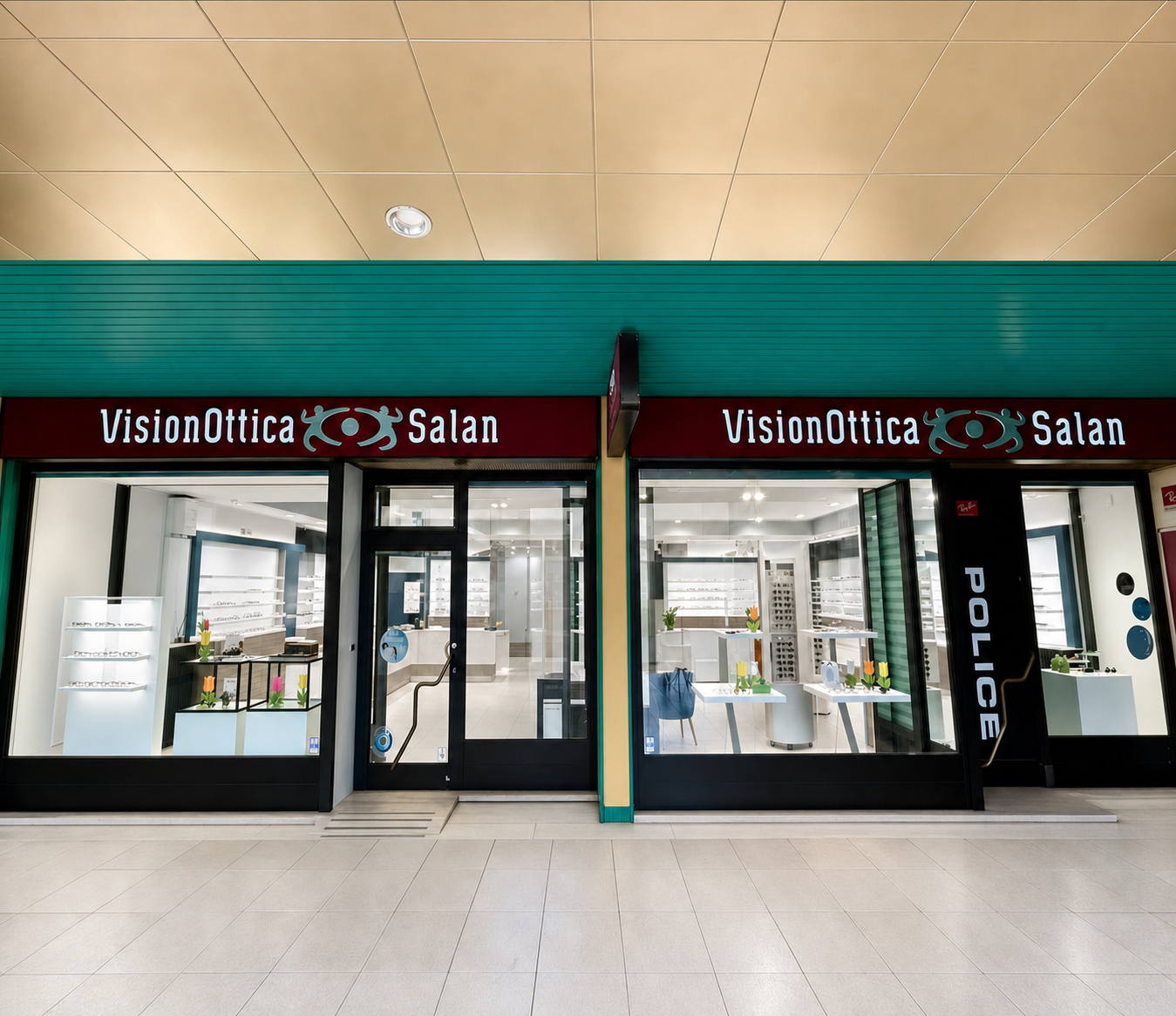 Facciata del negozio VisionOttica Salan di Bovolone in centro commerciale con doppia insegna bordeaux su fascia verde scuro, due ingressi a vetri e vetrine con espositori di montature