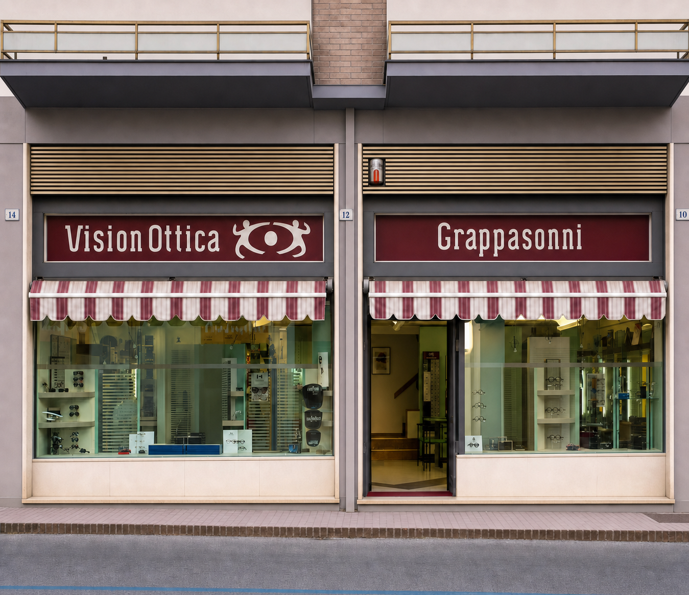 Facciata del negozio VisionOttica Grappasonni di Spoleto su strada con doppia insegna bordeaux e tende a righe bianche e rosse, due vetrine con espositori e porta centrale aperta